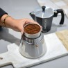 Main tenant une Cafetière italienne noir pour induction